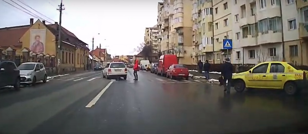 VIDEO: Accident pe trecerea de pietoni, evitat în ultima secundă. Șoferul intră pe contrasens să ocolească o femeie