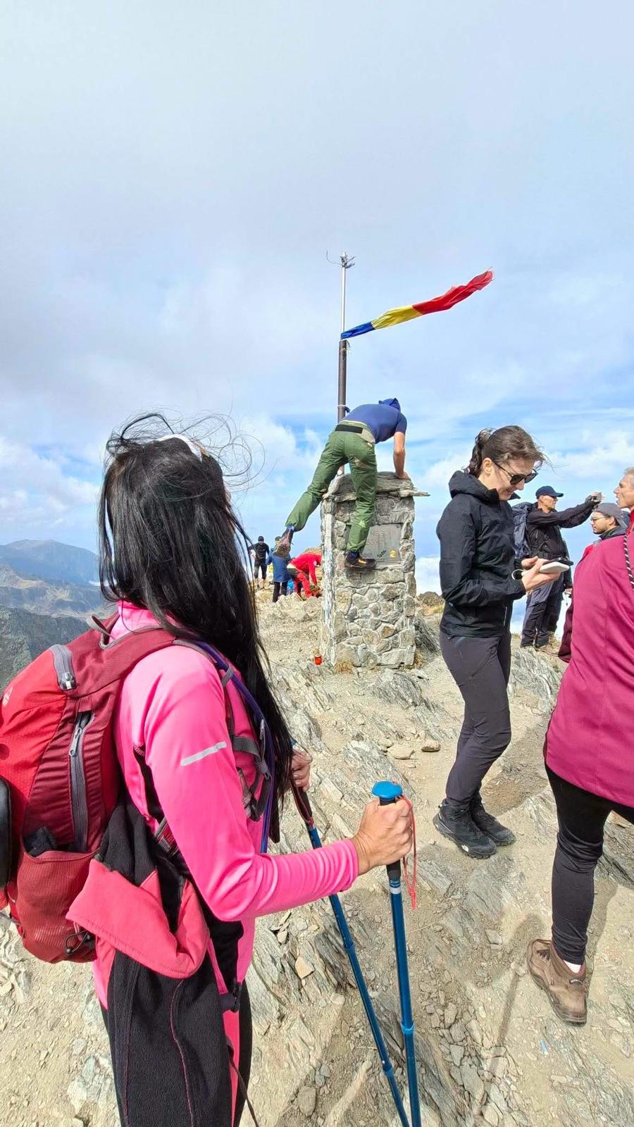 Turiști cocoțați pe borna Vârfului Negoiu pentru fotografii. „Nu scrie nicăieri că nu este voie”